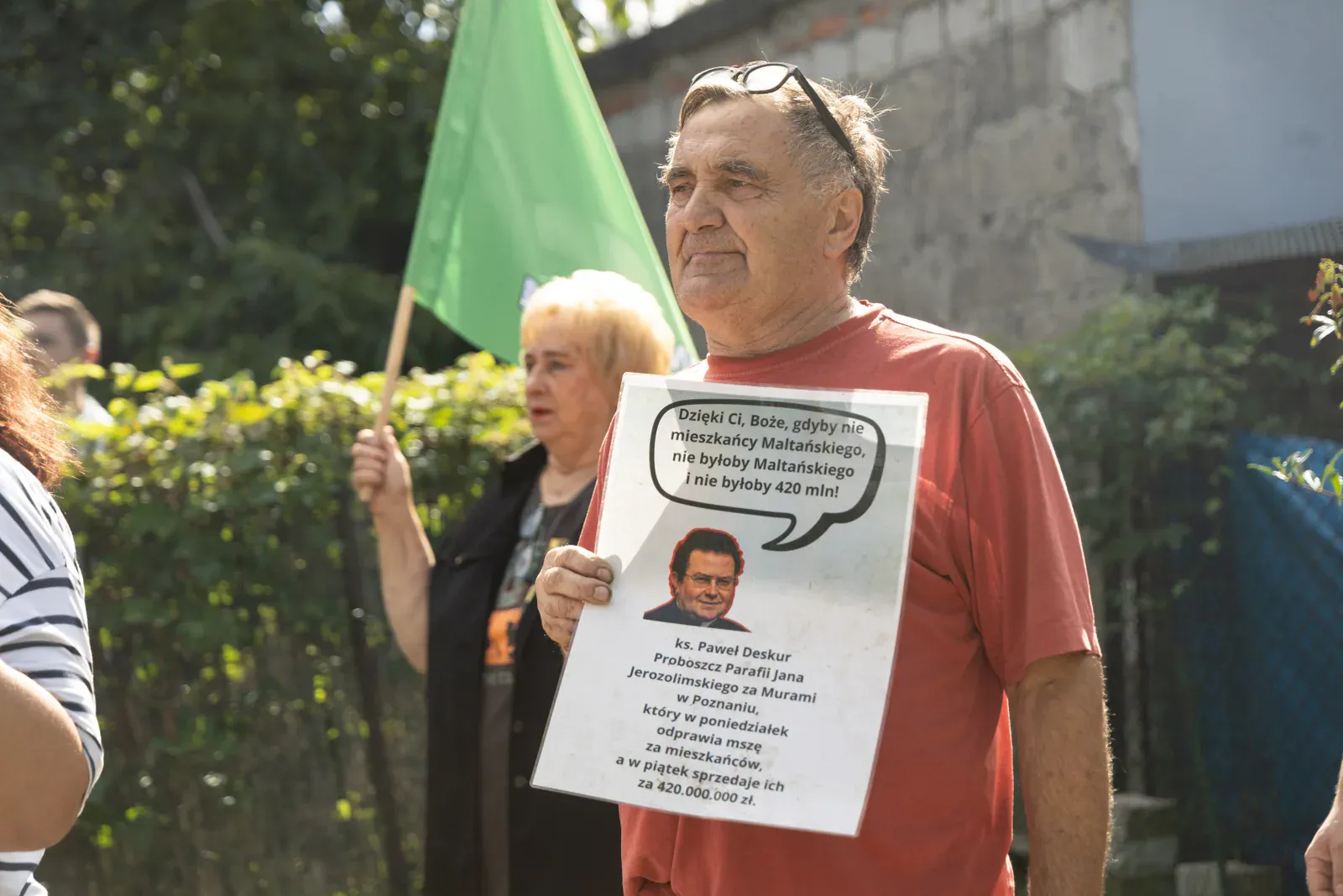 Uczestnik protestu trzyma planszę z cytatem przypisywanym proboszczowi parafii