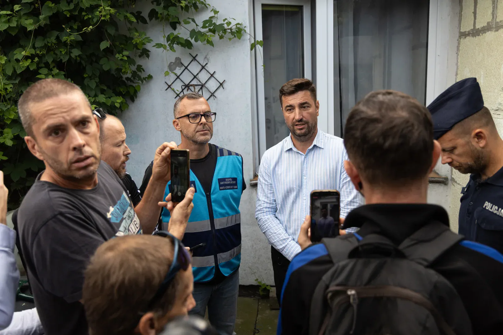 Zgromadzenie mieszkańców i dziennikarzy przy domu (10.28)