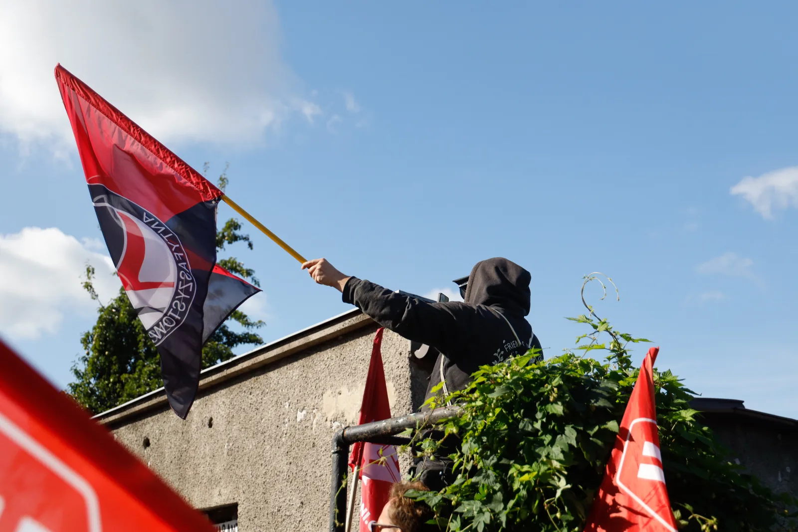 Flaga Akcji Antyfaszystowskiej nad dachem przybudówki (9.39)