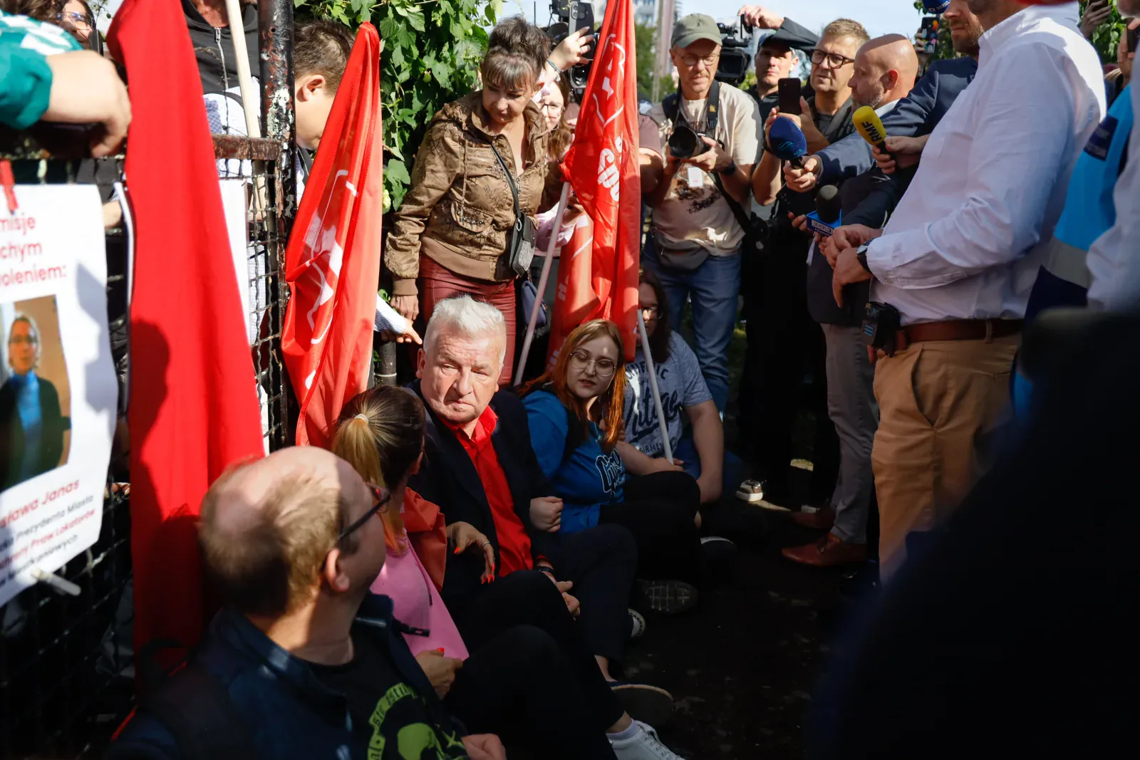Piotr Ikonowicz w siedzącej blokadzie przed bramą (9.58)