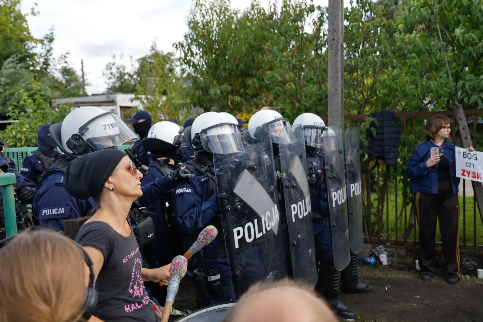 Protestująca z bębnem przed tarczami (11.26)