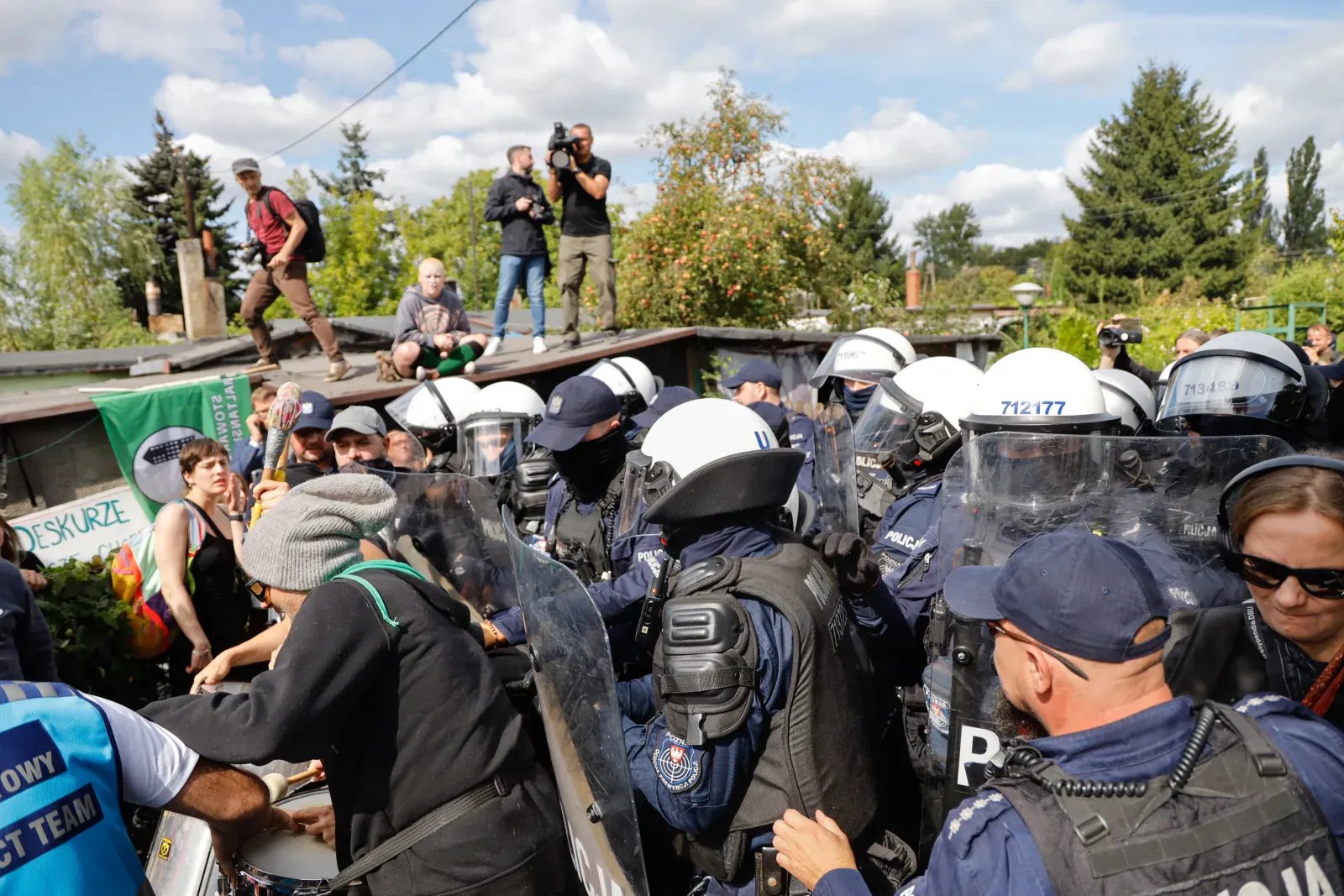 Funkcjonariusze z tarczami napierają na protestujących pod ogrodzeniem