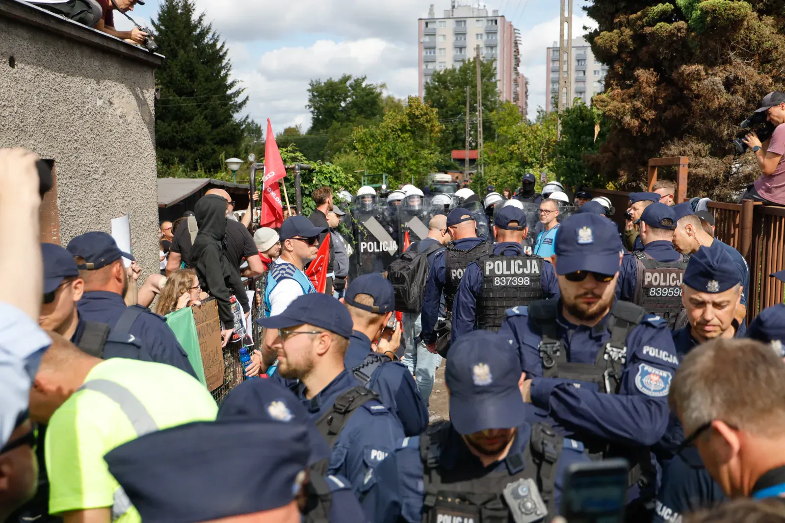 Policjanci wypełniają alejkę przy domu (11.35)