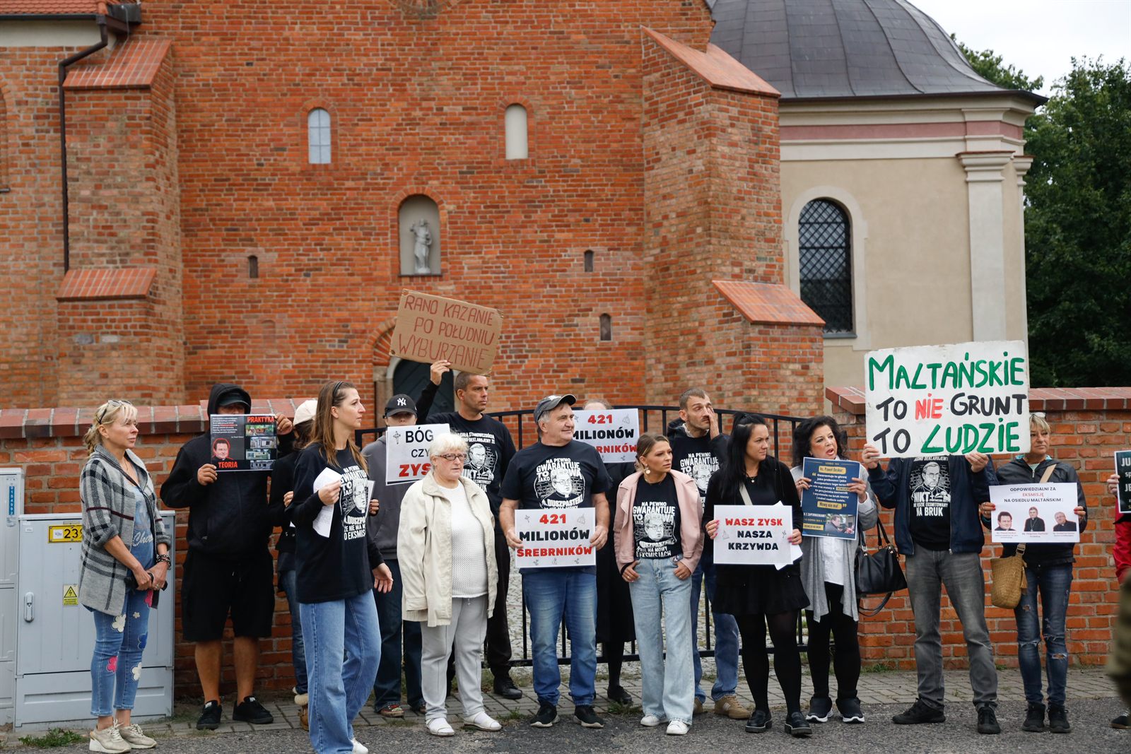 Zgromadzeni przed murem kościoła po Mszy o 12.00