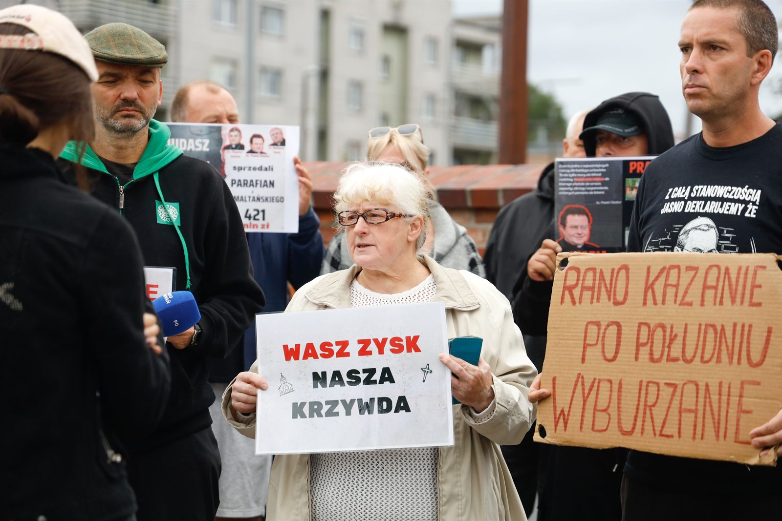 Parafianka z tabliczką przed mikrofonem stacji telewizyjnej
