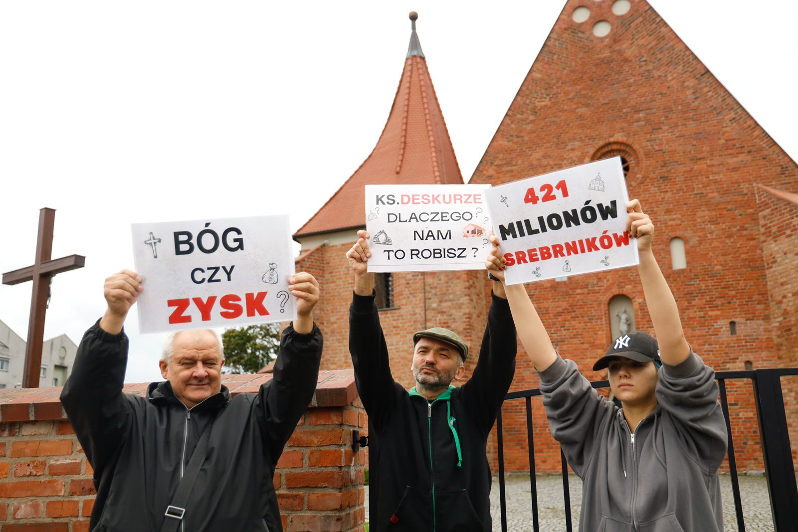 Trzy tablice przed fasadą kościoła