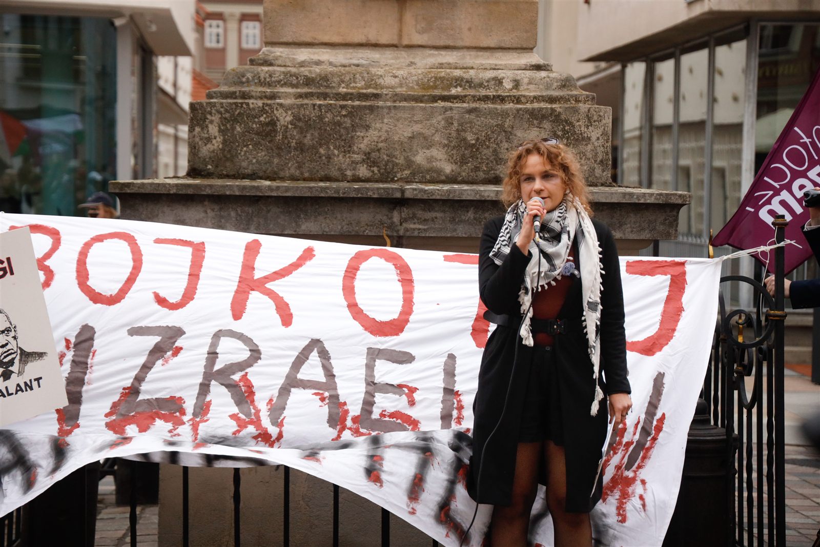 Transparent „Bojkotuj izraelski apartheid” rozpięty na balustradzie figury