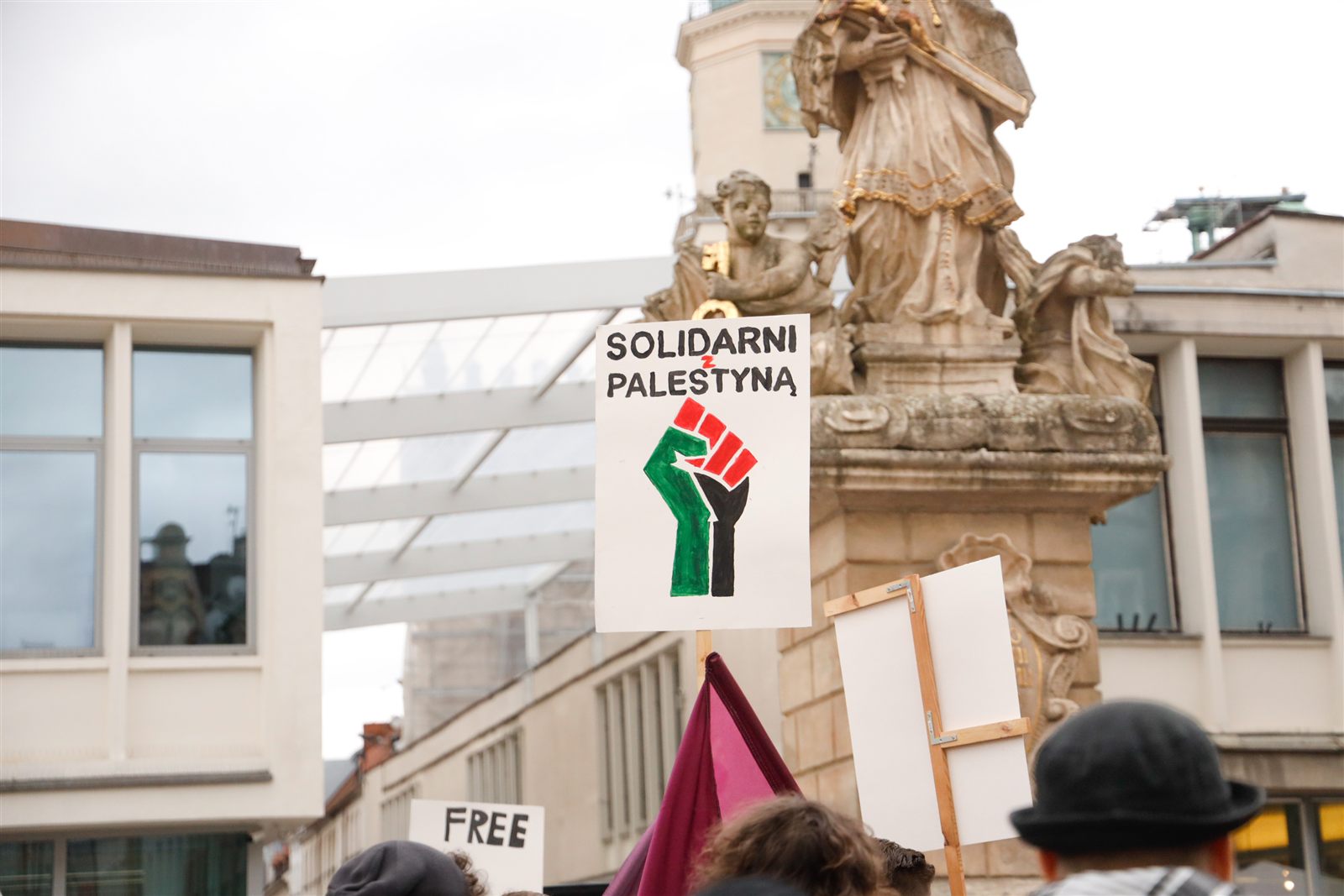 Plakat „Solidarni z Palestyną” na tle figury