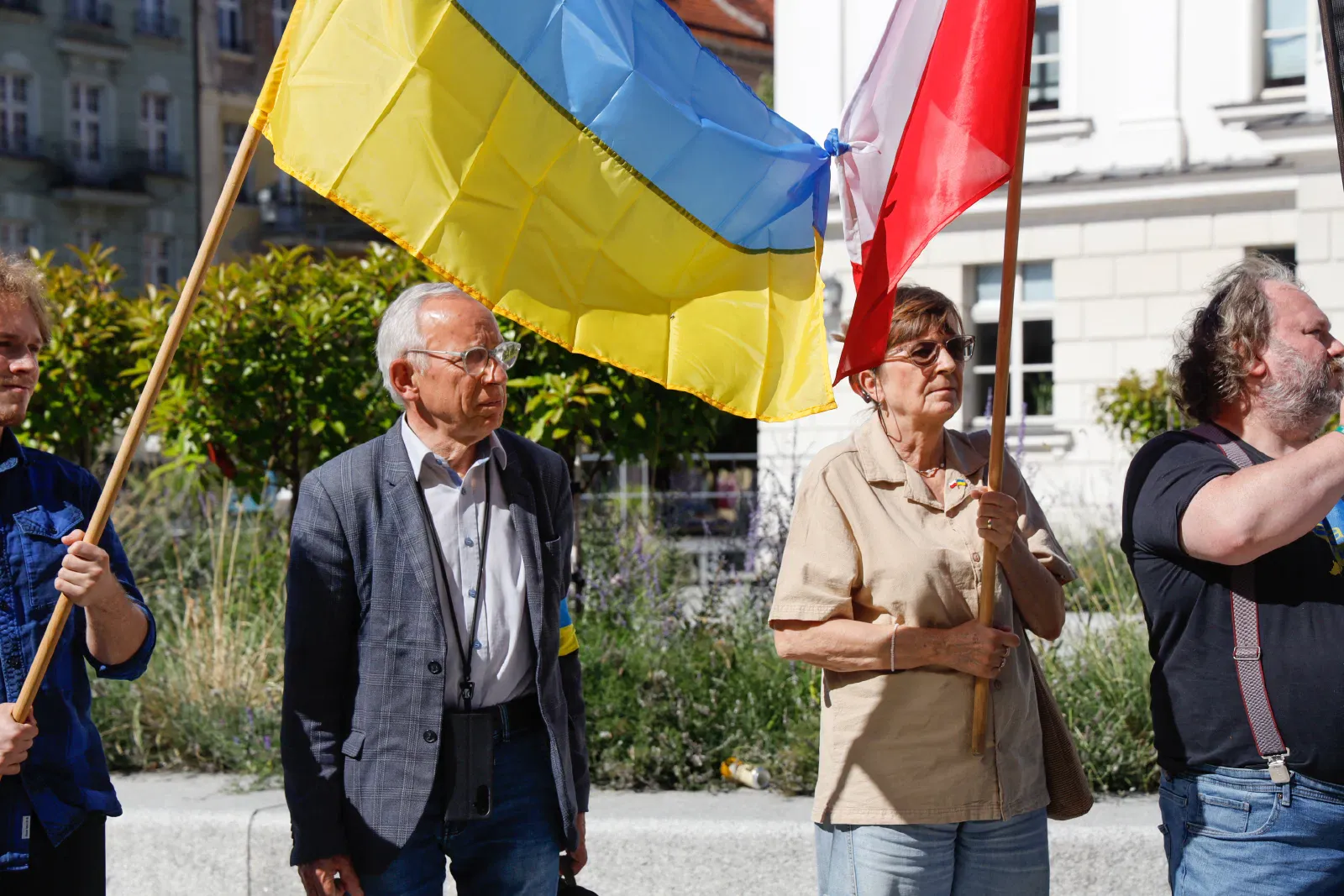 Osoby na proteście sygnalizującym Solidarność Polski z Ukrainą, widoczna jest flaga Ukrainy i Polski